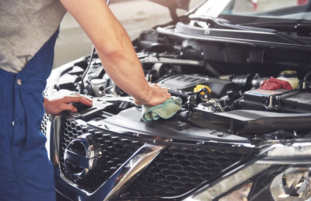 Picture showing muscular car service worker repairing vehicle